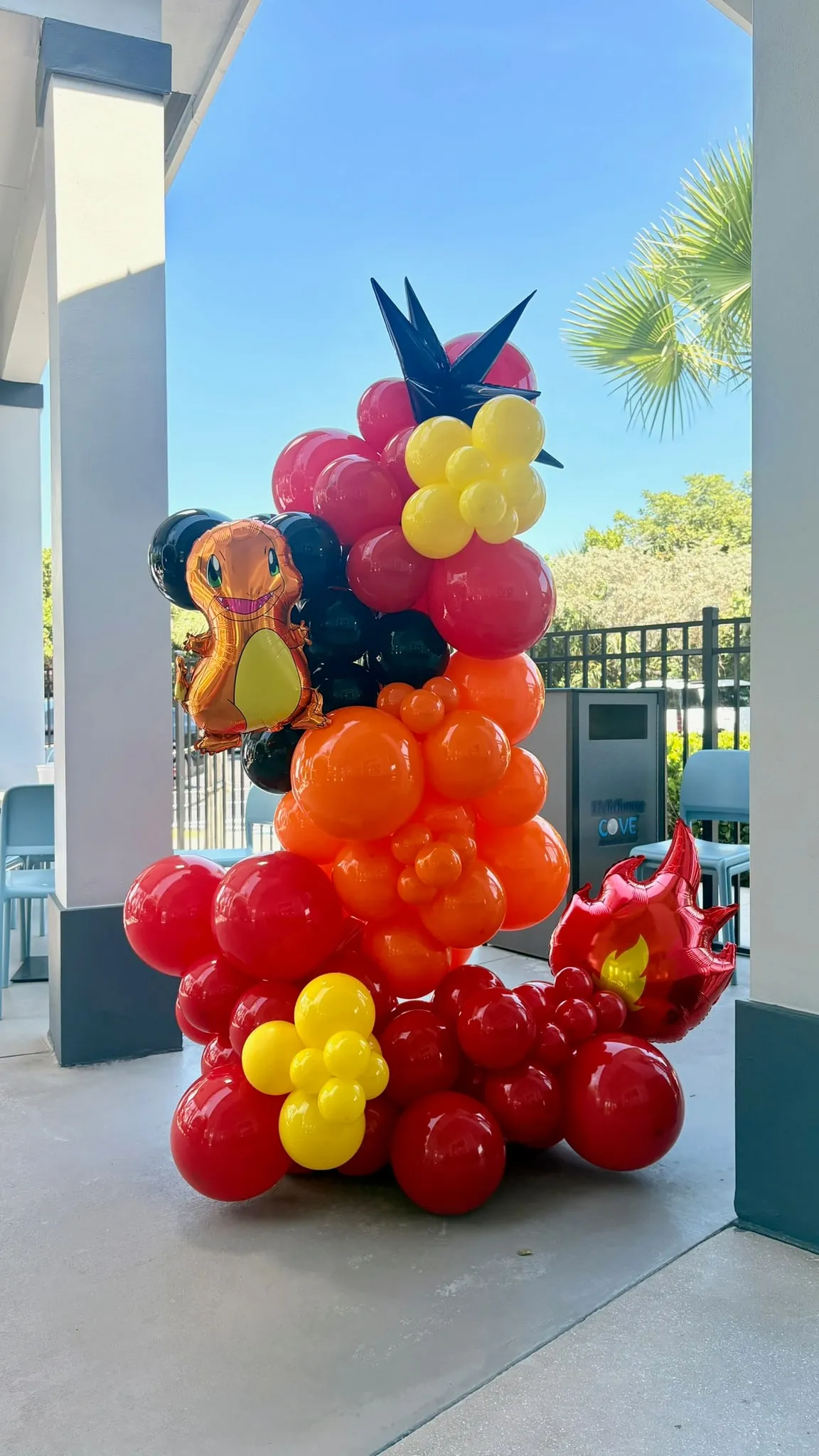 Balloon sculpture in red, orange and yellow with a small dragon character balloon