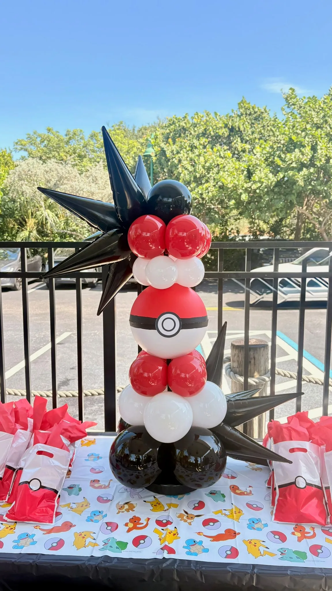 Small balloon column in red, white and black with black starbursts on a party table